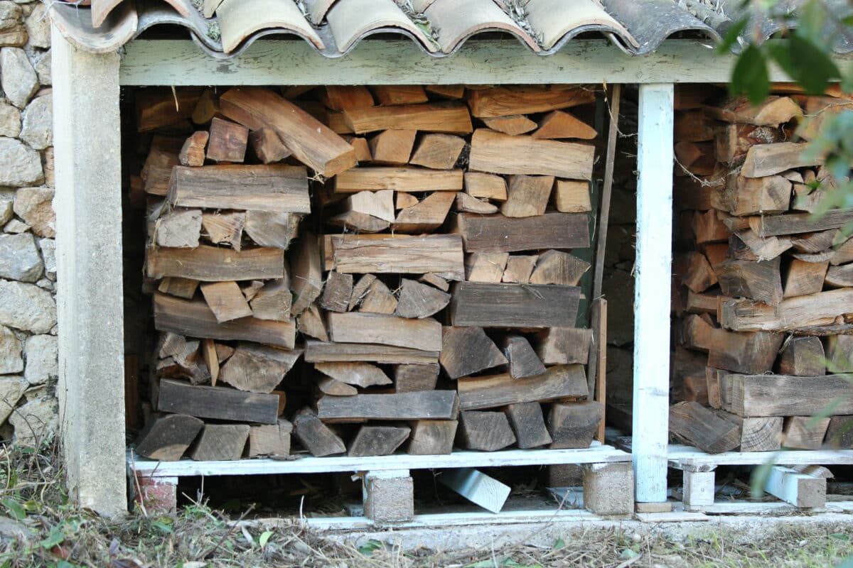 Sécurité et préservation : dans cette enceinte de béton et de bois traité, chaque bûche est à l'abri des insectes et de l'humidité. Malgré une protection grâce au toit, on voit que les buches qui ont grisé ont été exposées à une humidité supérieure à  20%.