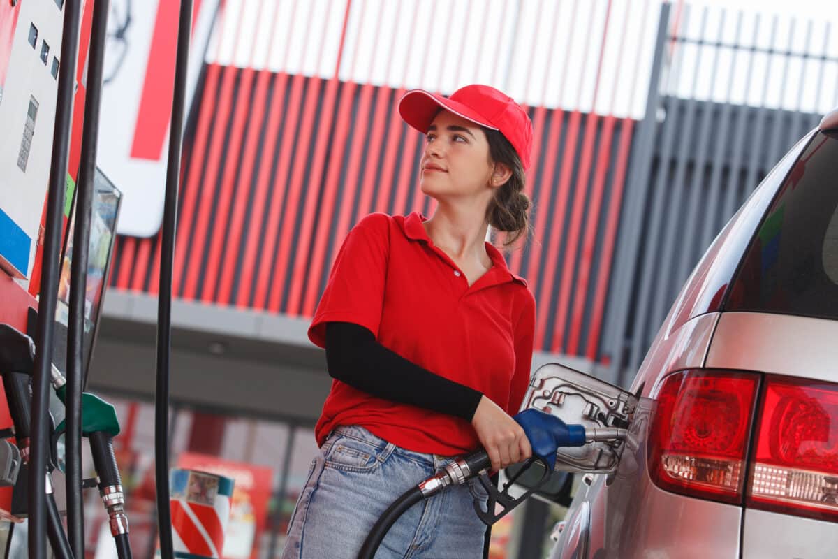 Une jeune femme fait le plein de carburant en station