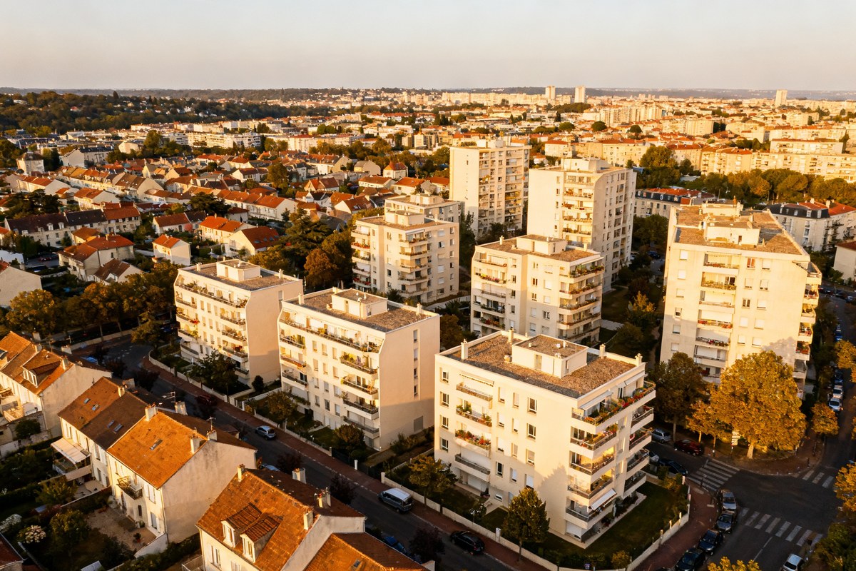 Vue aérienne d'une ville résidentielle française avec maisons et immeubles au coucher du soleil