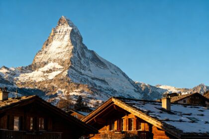Le sommet du Cervin sous un ciel bleu au-dessus des toits d'un village alpin enneigé